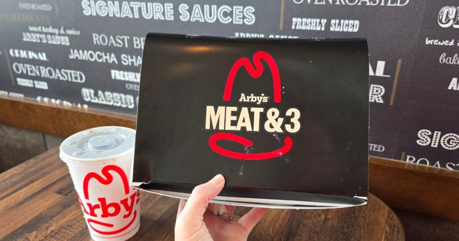 hand holding arbys meat & 3 meal box in store