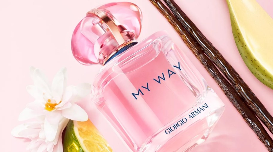 a bottle of perfume shown with vanilla bean and blossom