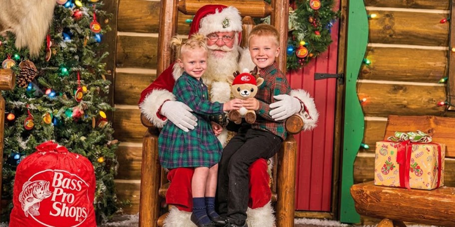 kids sitting with santa holding reindeer toy 