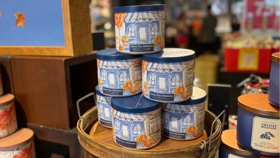 a stack of fall 3 wick candles in a bath and body works store