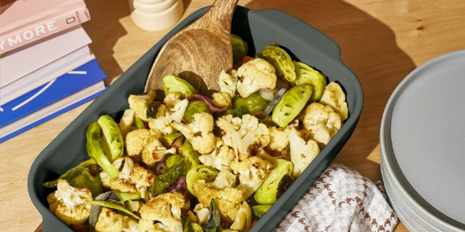 green stoneware dish with veggies on table