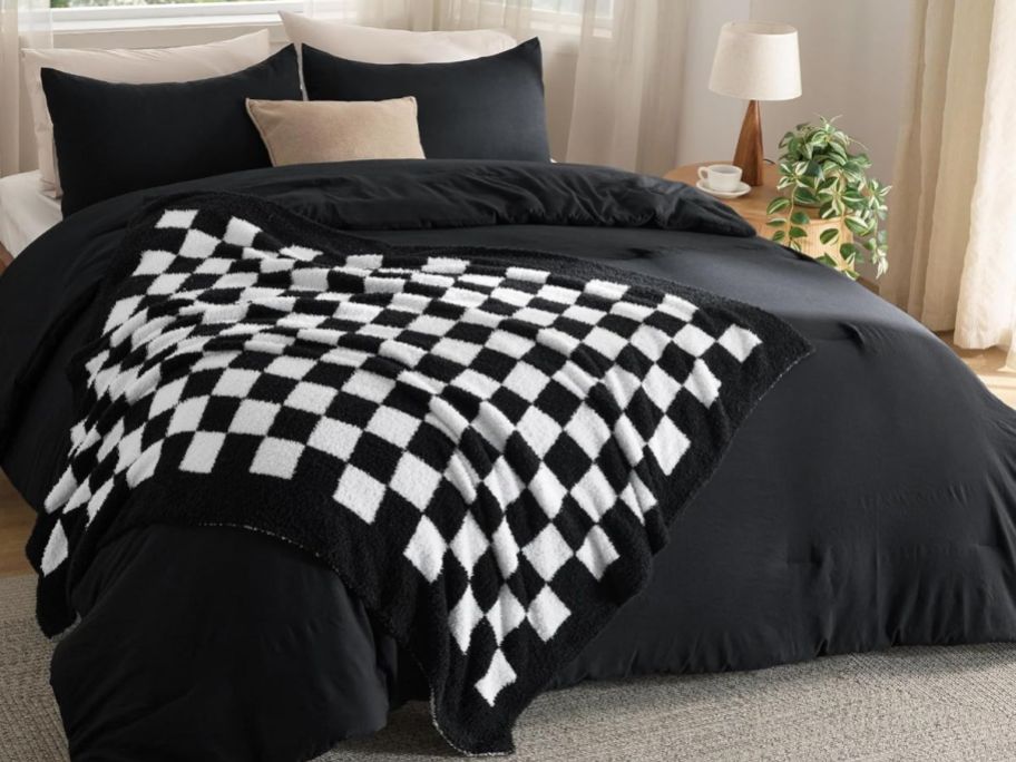 black and white checkered blanket on comforter on bed