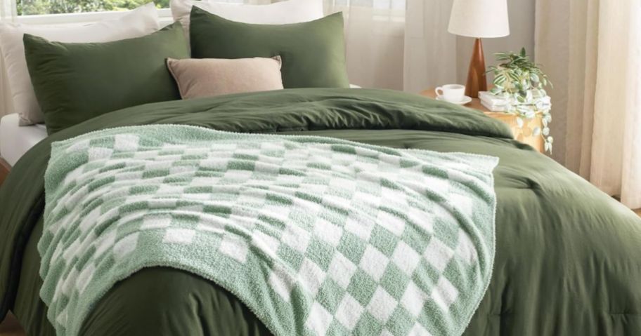 green and white checkered blanket on comforter on bed