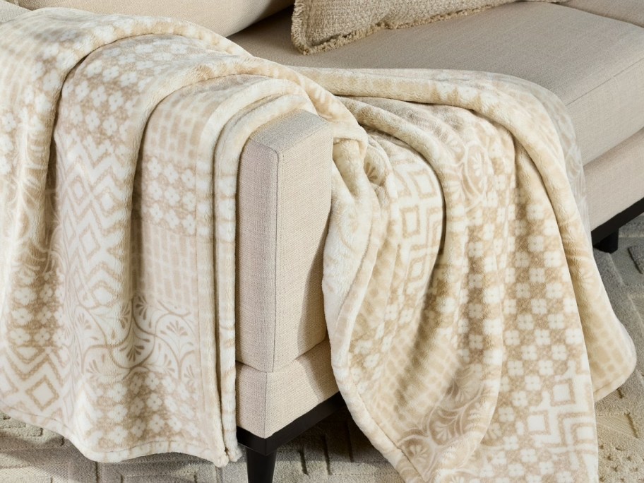 a beige and biscuit colored throw in a printed patchwork pattern