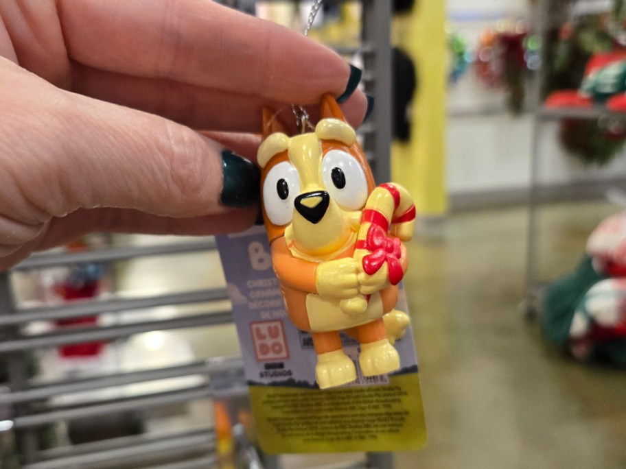 A hand holding up a Bingo ornament at Kohls.