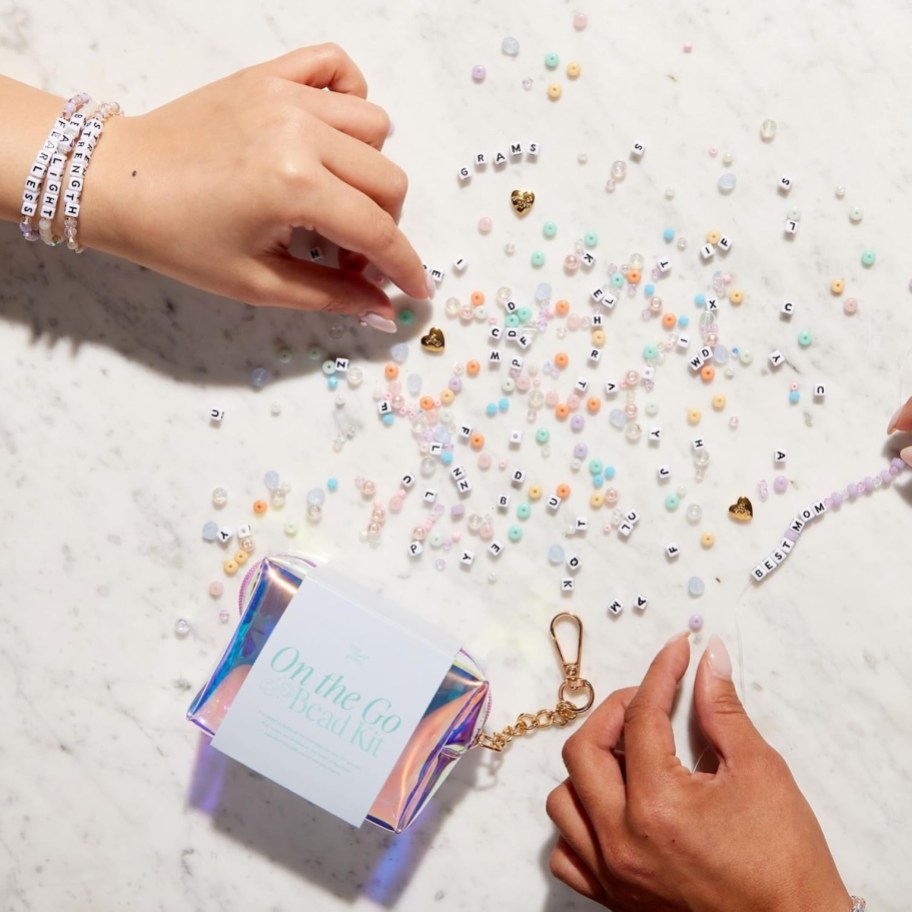 close up of hands making bead bracelets