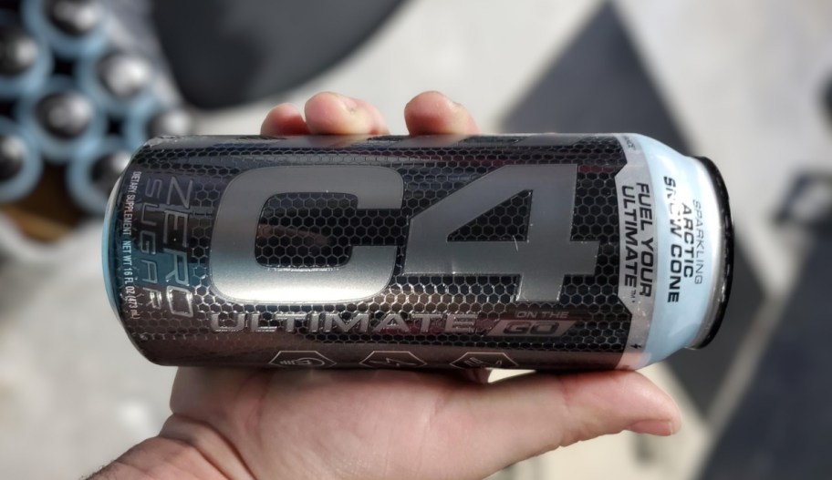 a mans hand holding a can of c4 energy drink arctic snow cone flavor