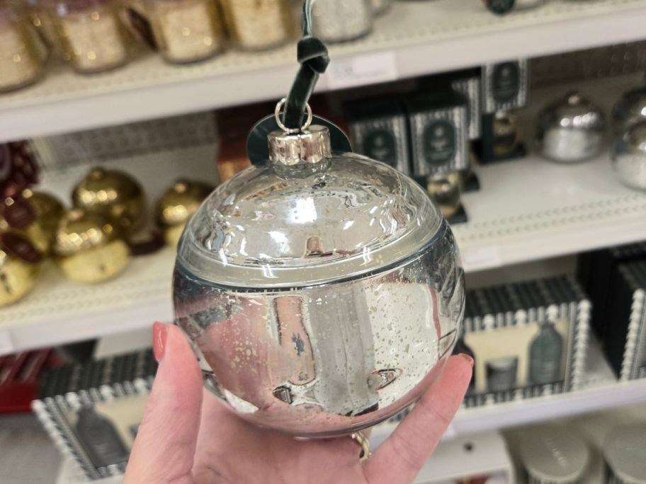 silver Threshold Ornament Figural 7oz Jar Candle in hand in store