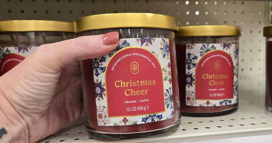 hand holding christmas cheer candle in store
