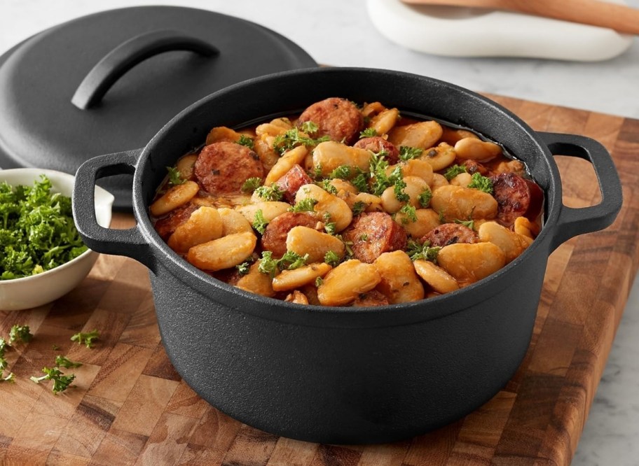 a 2Qt cast iron dutch oven with beans and sausage in it