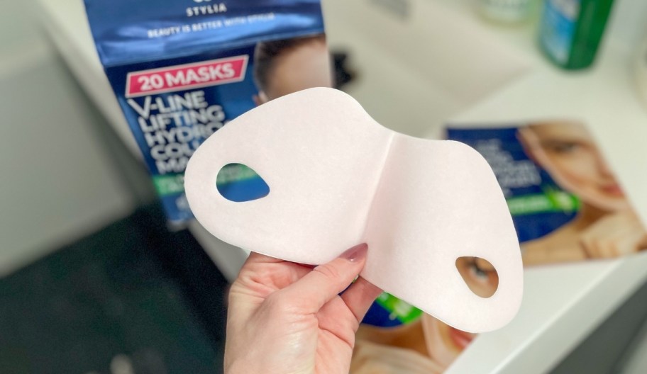 a womans hand holding vline chin mask