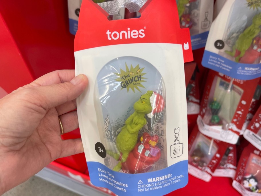 hand holding a package with a Grinch Tonies figure