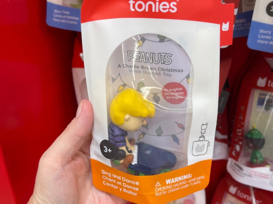 hand holding a package with a Linus from Peanuts Tonies figure