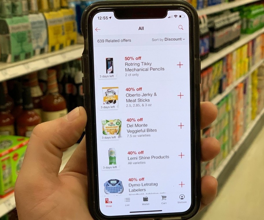 a mans hand holding a phone with target circle app offers showing