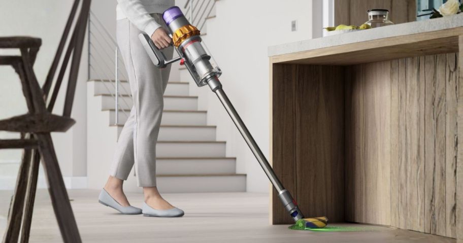 person using dyson vacuum in house