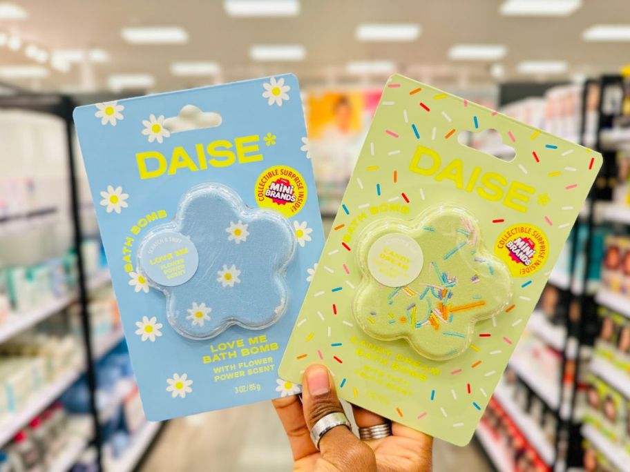 hand holding two daise bath boombs at the store