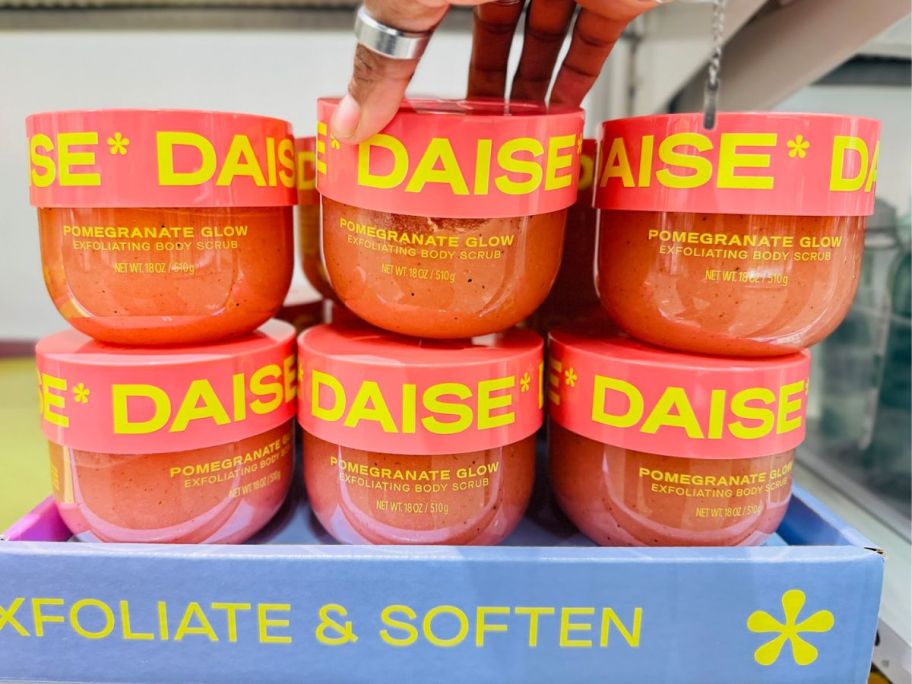 display of multiple daise body scrubs on a shelf