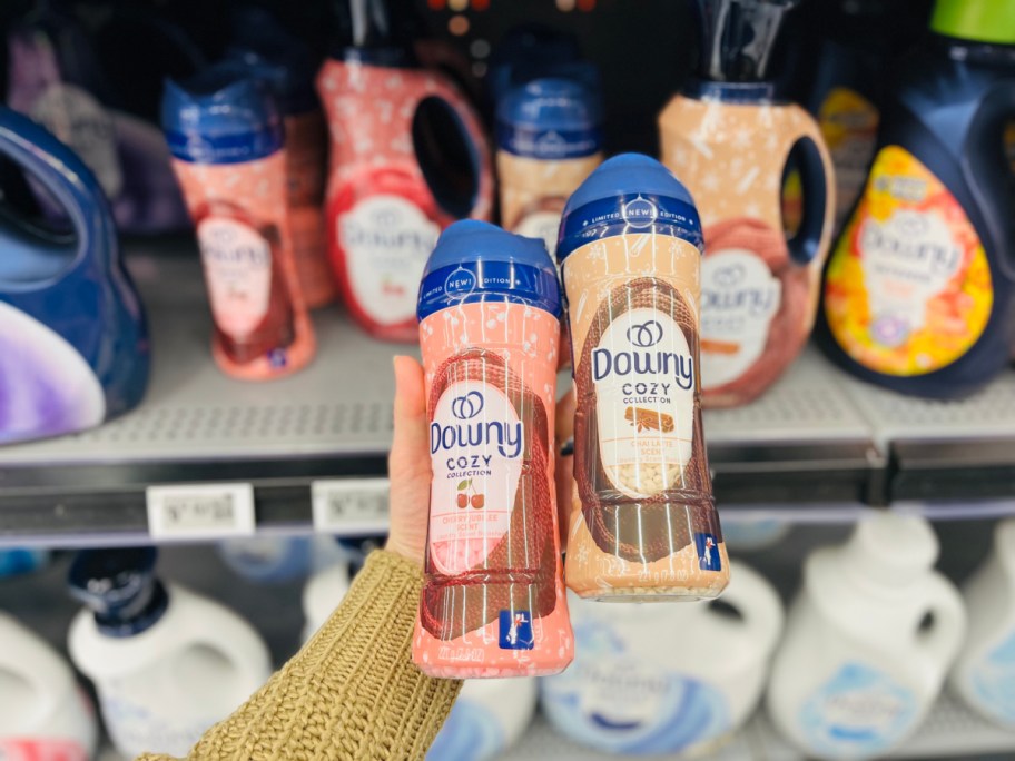 hand holding bottles of downy scent beads in a store