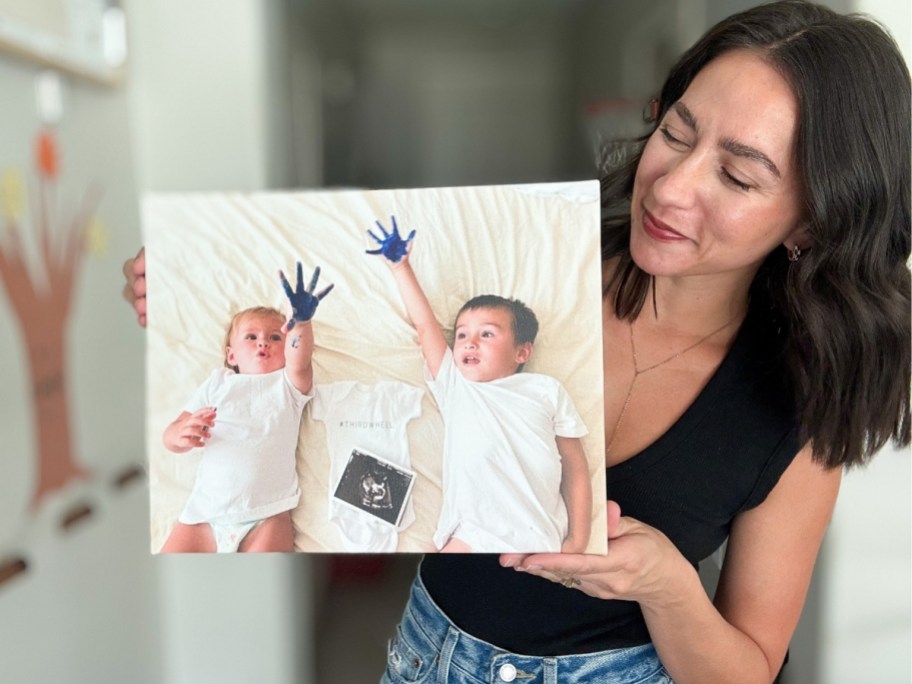 woman holding a canvas print phots of her kids
