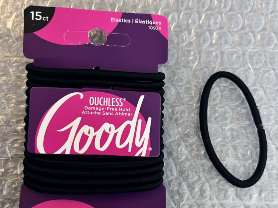 one black hair tie next to packaging