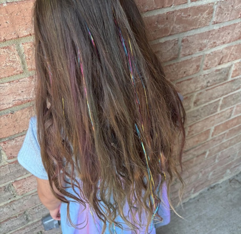 back of girls hair with rainbow tinsel