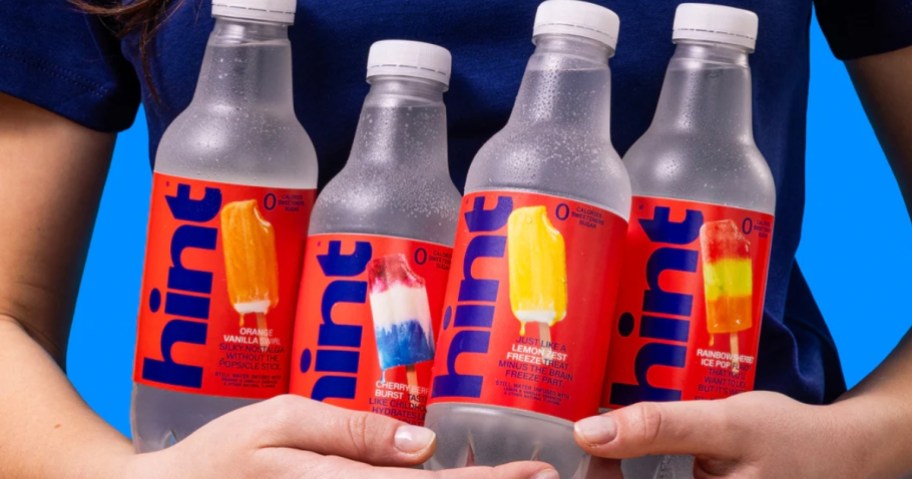 mans hands holding 4 bottles of Hint flavored water