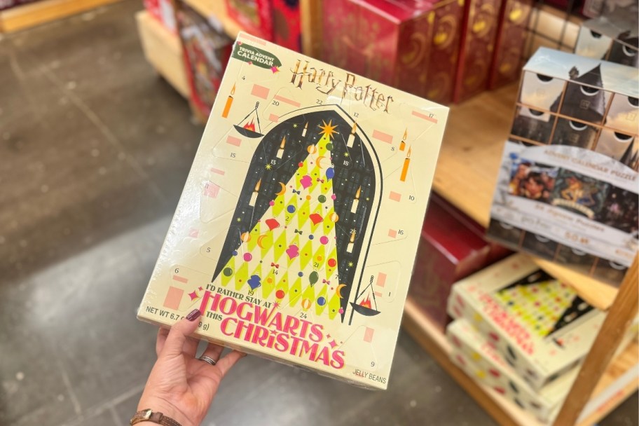 a womans hand holding a hogwarts advent calendar
