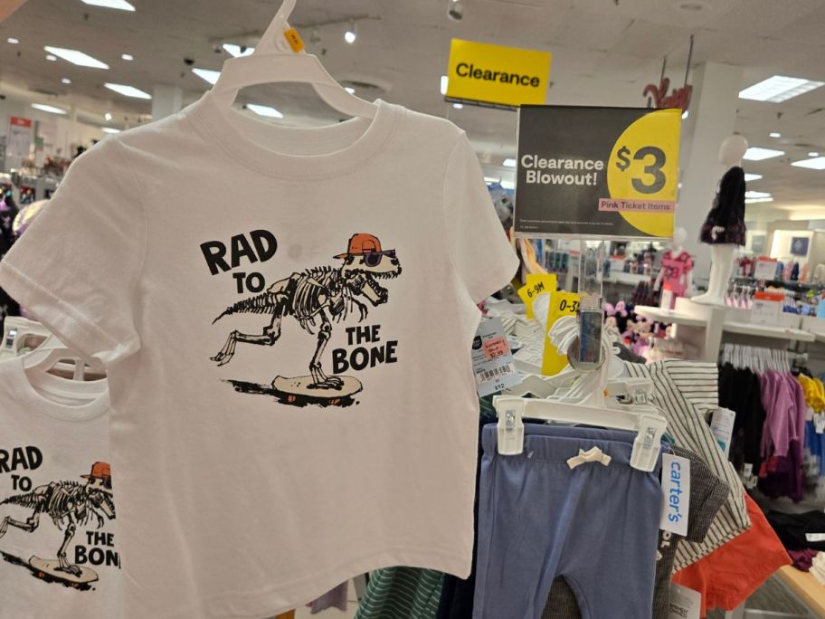 kids clothing in store with $3 clearance sign in the background