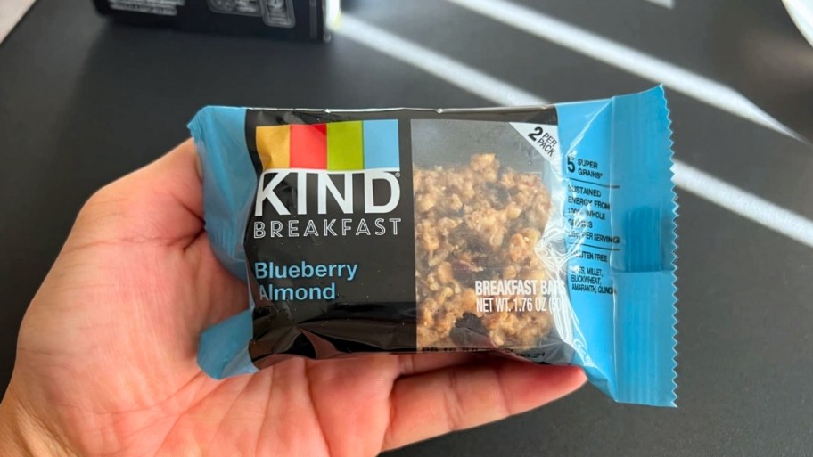 womans hand holding a kind breakfast bar 2 pack