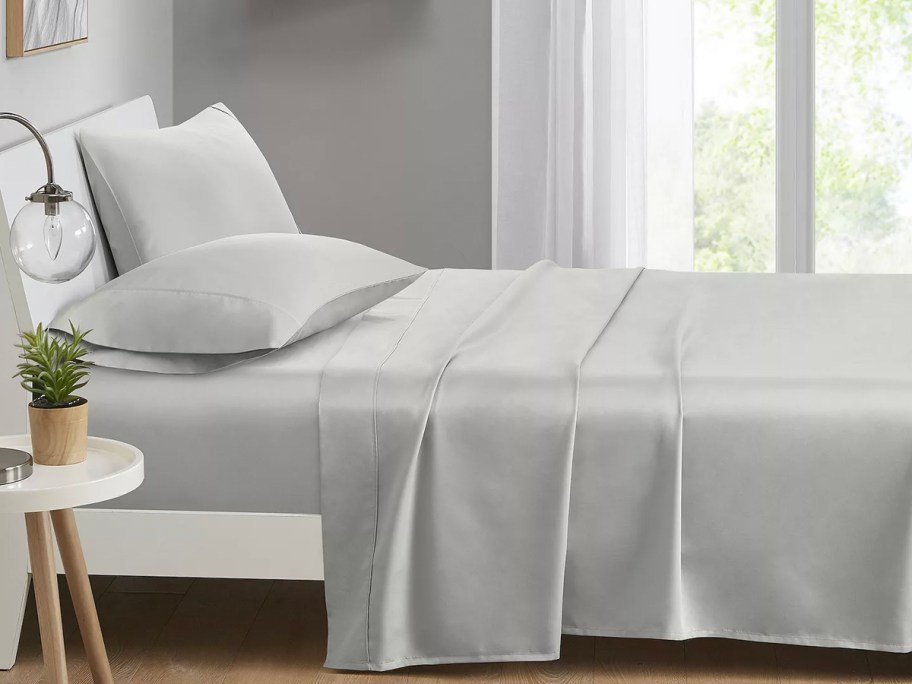 gray sheets on bed with pillows 