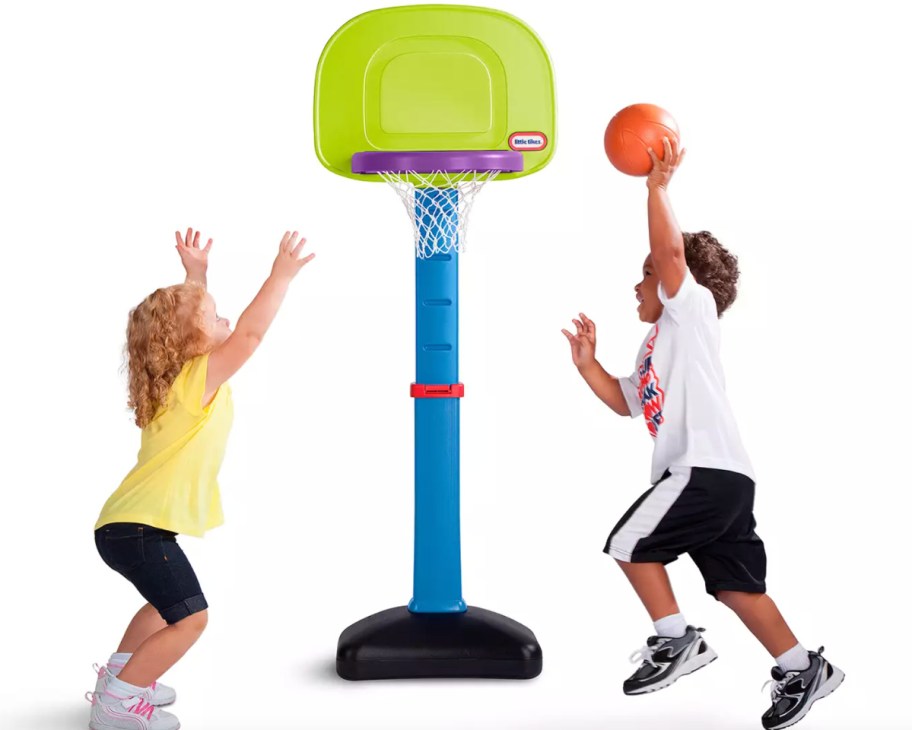 two kids playing on mini basketball hoop