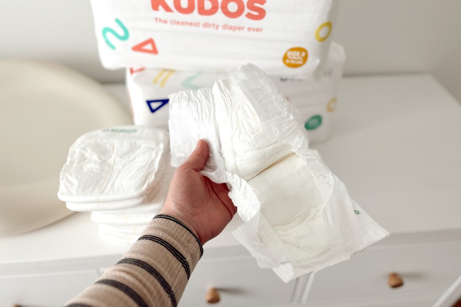 hand holding open a white cotton diaper
