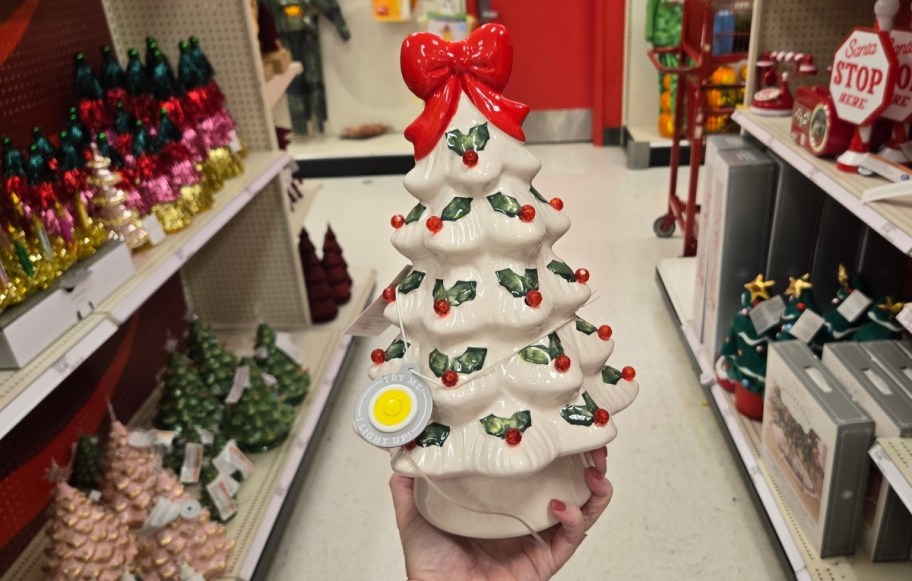 a womans hand holding a ceramic led christmas tree