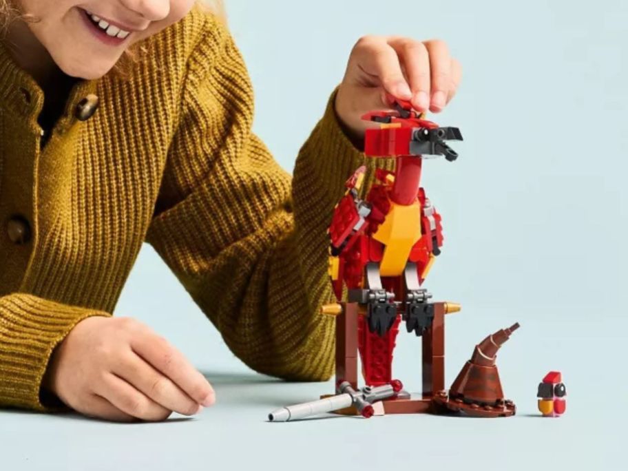 kid playing with LEGO Harry Potter Fawkes: Dumbledore’s Phoenix