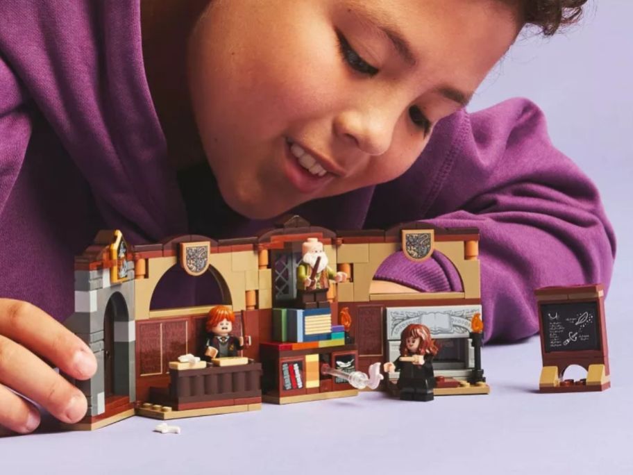 kid playing with LEGO Harry Potter Hogwarts Castle Charms Class