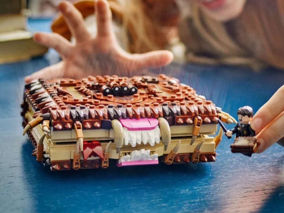 kid reaching for LEGO Harry Potter Chomping Monster Book of Monsters