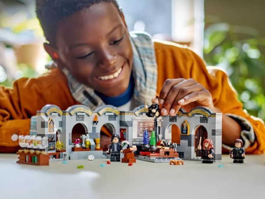 kid playing with LEGO Harry Potter Hogwarts Castle: Potions Class