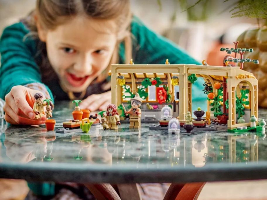 kid playing with LEGO Harry Potter Hogwarts Castle: Herbology Class