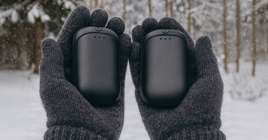 person holding black hand warmers