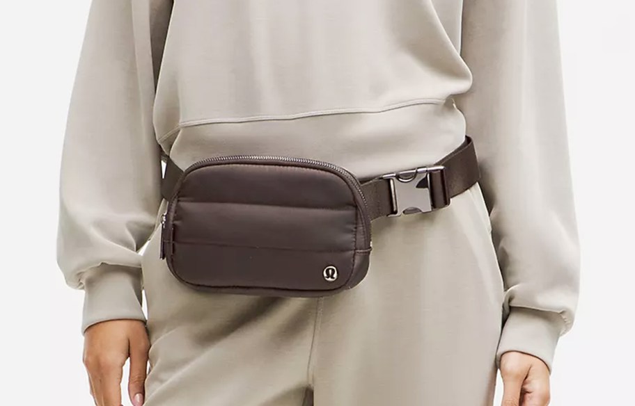 woman in a matching sweatsuit with a brown belt bag