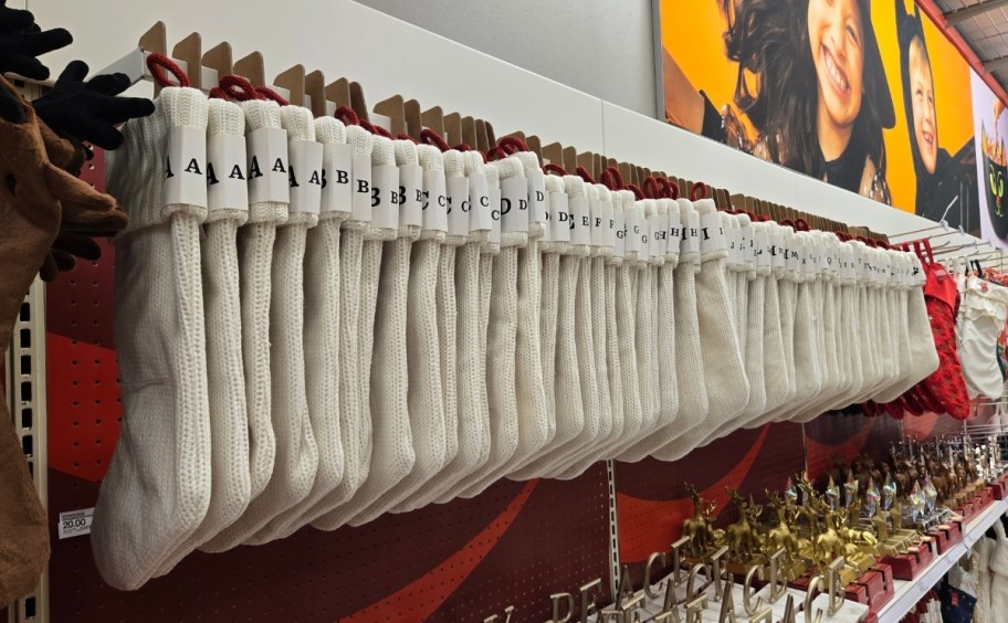 white monogram christmas stocking hanging in a row on display in a target store