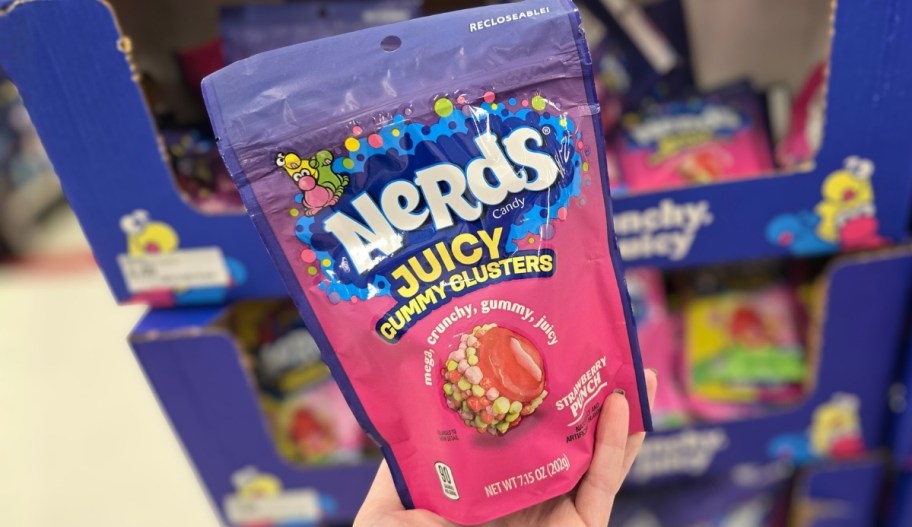 a womans hand holding a bag of candy