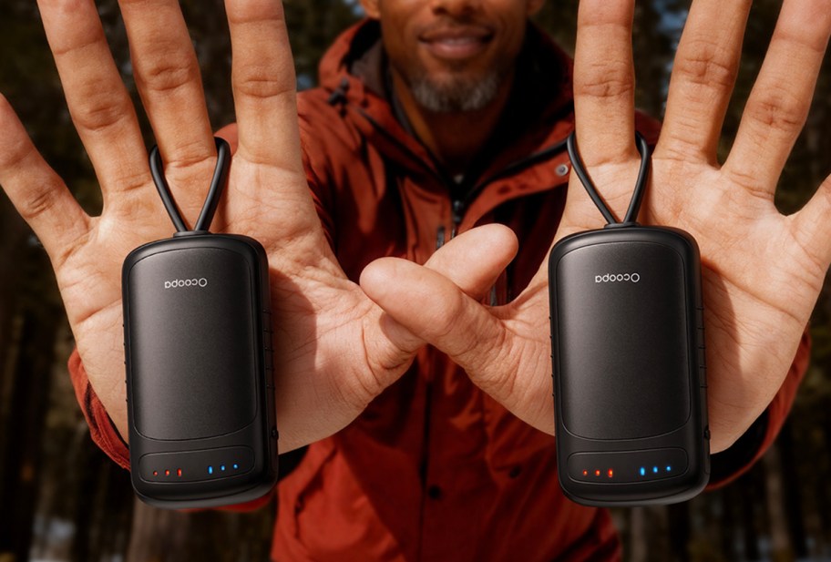 hands holding black hand warmers 