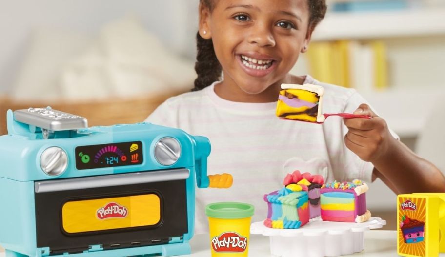 a little girl playing with the play doh super slice cake playset