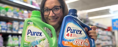 smiling woman holding two bottles of purex in a store
