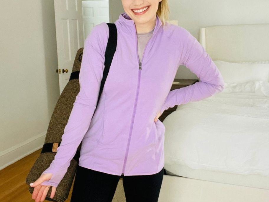 woman wearing a purple tek gear jacket inside of a bedroom 