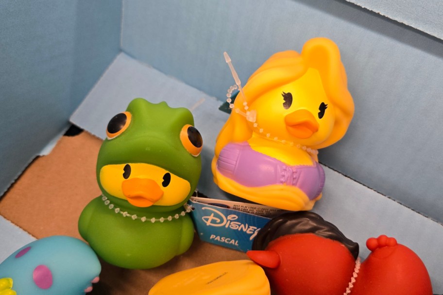 rubber duck in green frog suit, rubber duck with purple dress and yellow hair