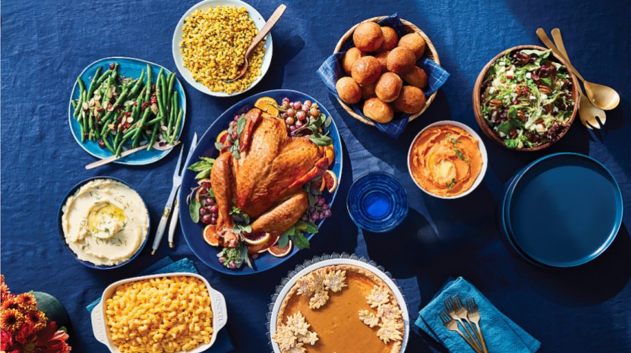table set with Thanksgiving dinner on a blue tablecloth