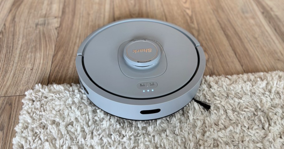 shark robot vacuum on a white shag rug