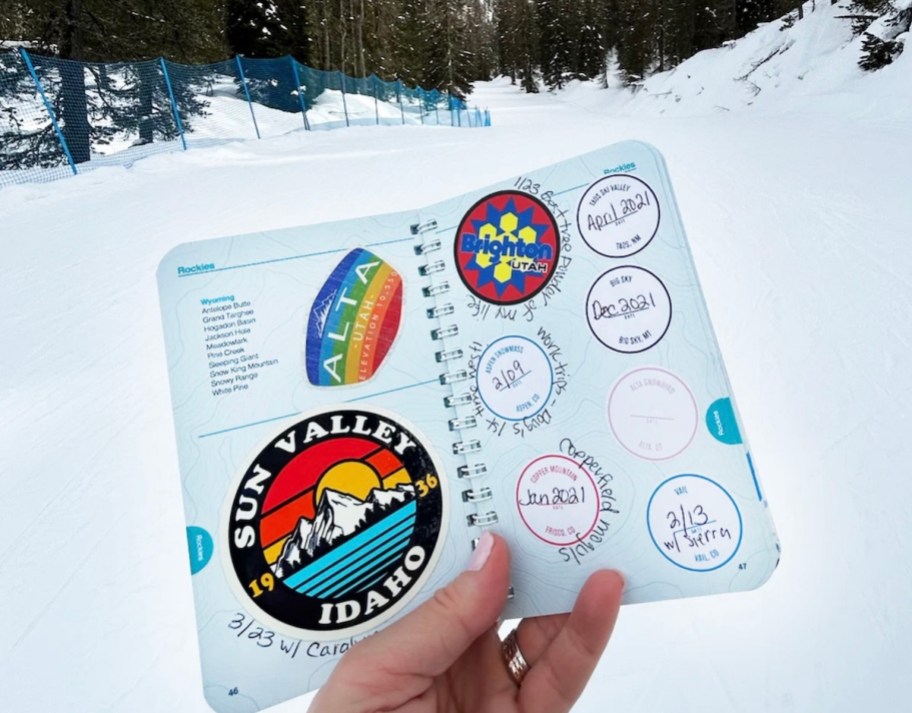 hand holding ski passport with stickers